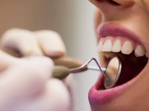 Dentista examinando las encías de una paciente